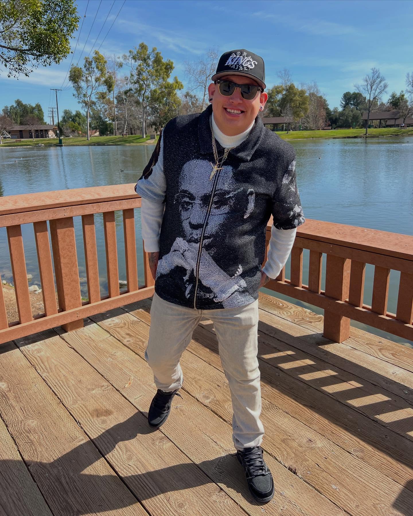 Customer on a lakeside pier in a Byepound Dept tapestry jacket