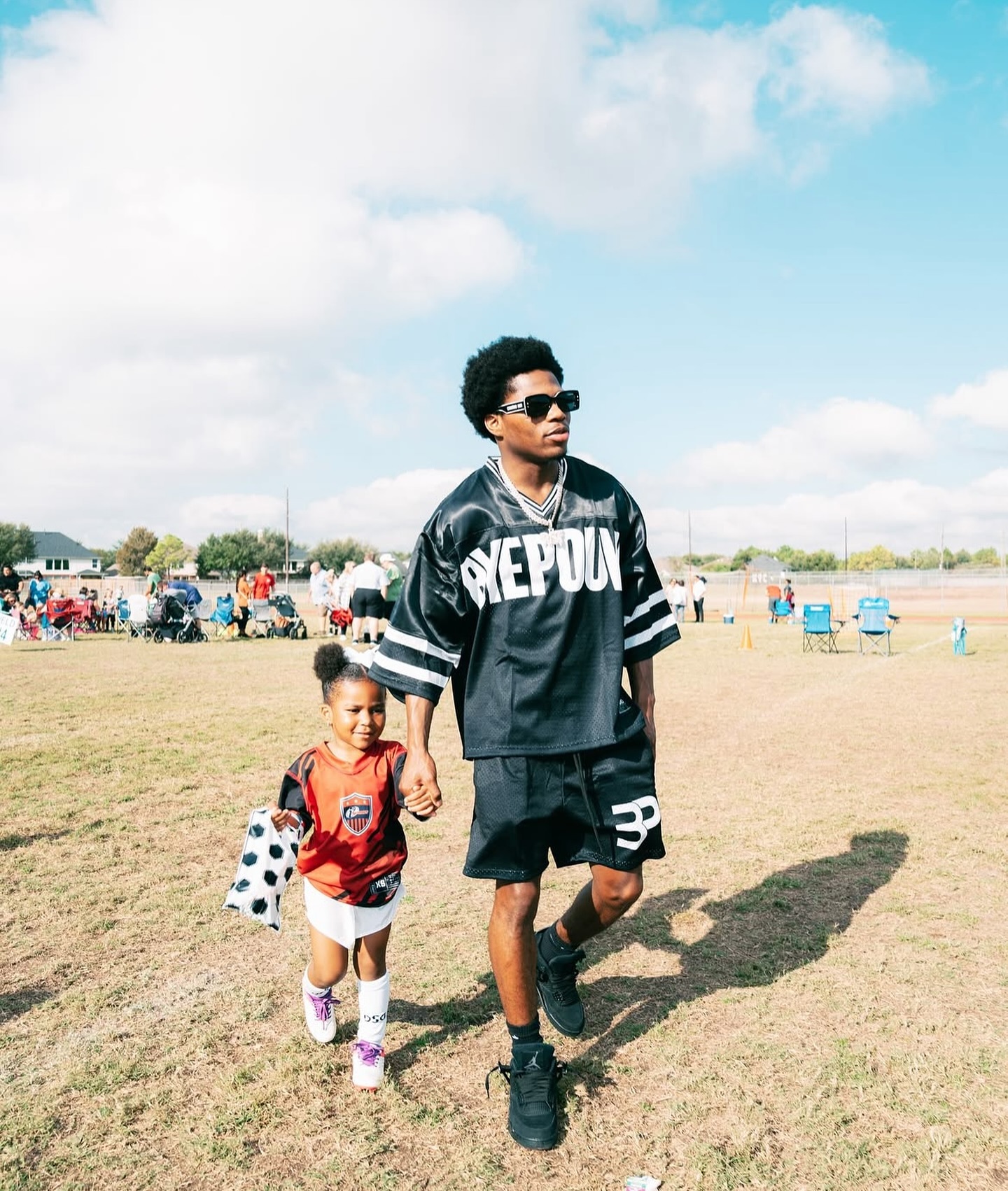Byepound mesh football jersey on game day with a young fan